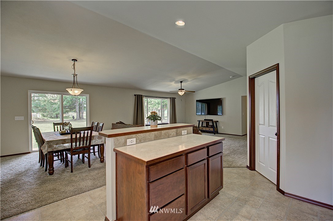 5138 180th Trail Southwest Rochester, WA 98579 - Photo 10 of 33 a view of kitchen with kitchen island a sink dining table and chairs