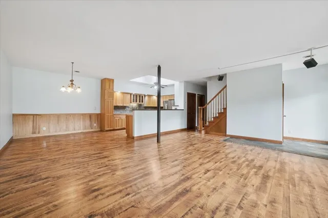 a view of a kitchen with wooden floor and a refrigerator