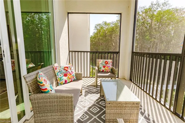 a living room with furniture and a floor to ceiling window