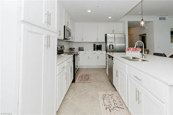 a kitchen with white cabinets and appliances