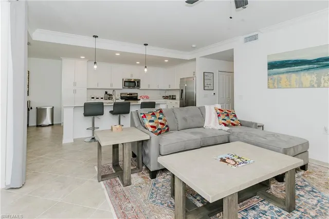 a living room with furniture a rug and kitchen view