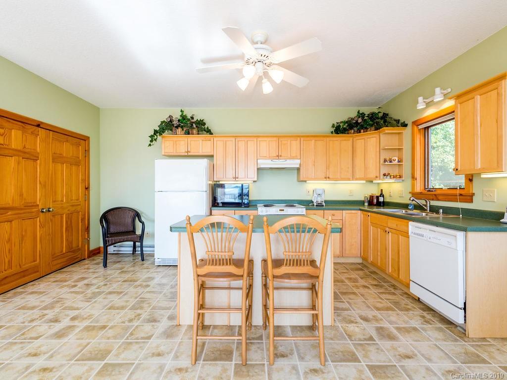 1299 Pine Ridge Road Burnsville, NC 28714 - Photo 13 of 41 a kitchen with granite countertop a stove a sink and a dining table chair