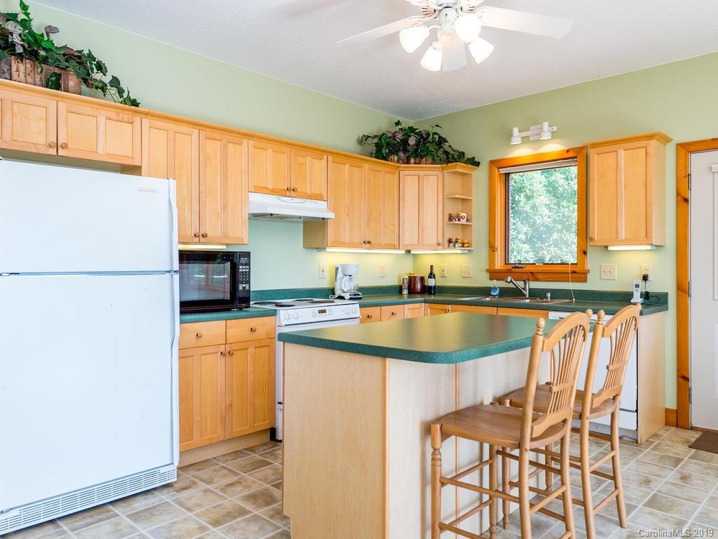1299 Pine Ridge Road Burnsville, NC 28714 - Photo 14 of 41 a kitchen with a refrigerator a sink dishwasher and a stove with wooden floor