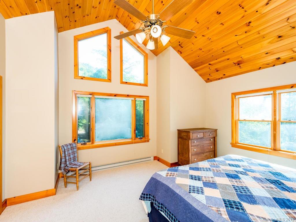 1299 Pine Ridge Road Burnsville, NC 28714 - Photo 21 of 41 a bedroom with a bed and wooden floor
