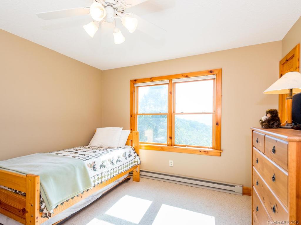 1299 Pine Ridge Road Burnsville, NC 28714 - Photo 24 of 41 a bedroom with a bed and a large window