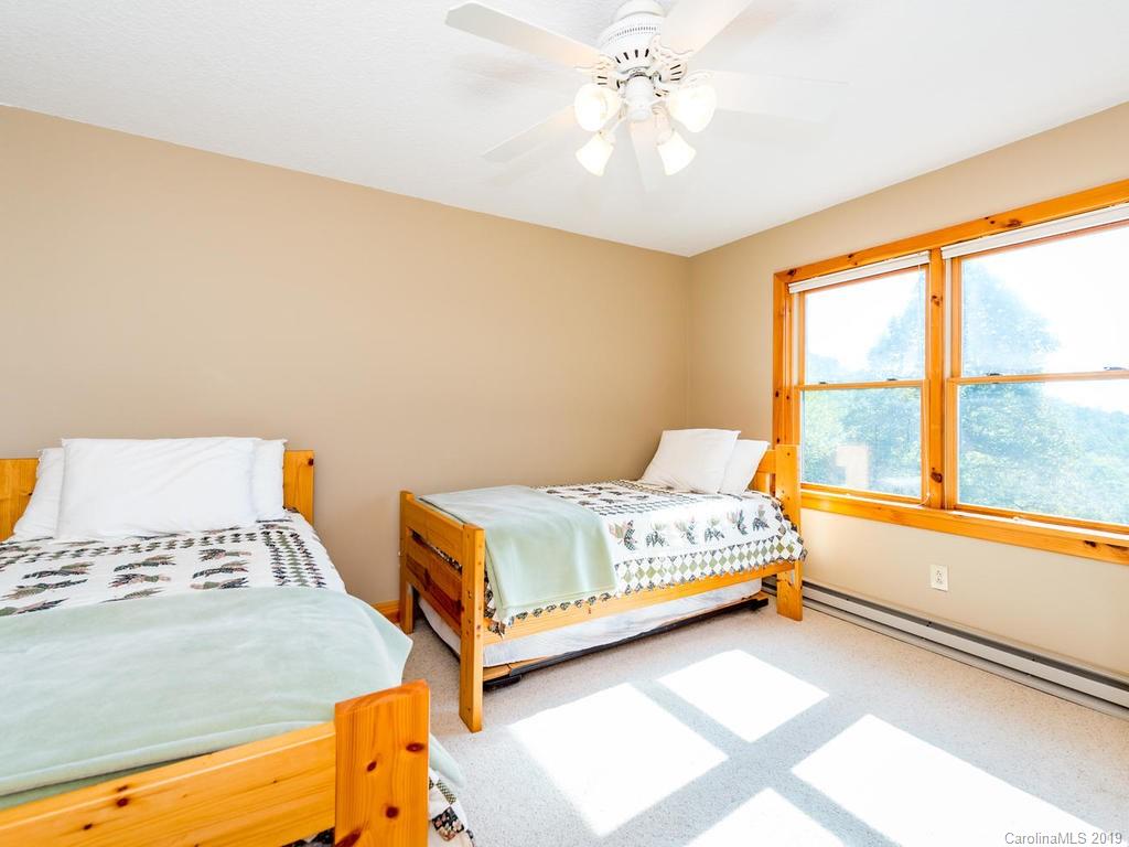 1299 Pine Ridge Road Burnsville, NC 28714 - Photo 25 of 41 a bedroom with a bed and a window