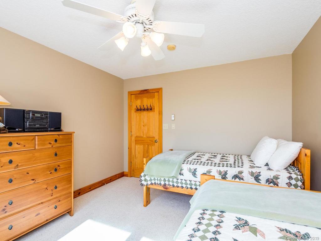 1299 Pine Ridge Road Burnsville, NC 28714 - Photo 26 of 41 a bedroom with a bed and wooden floor