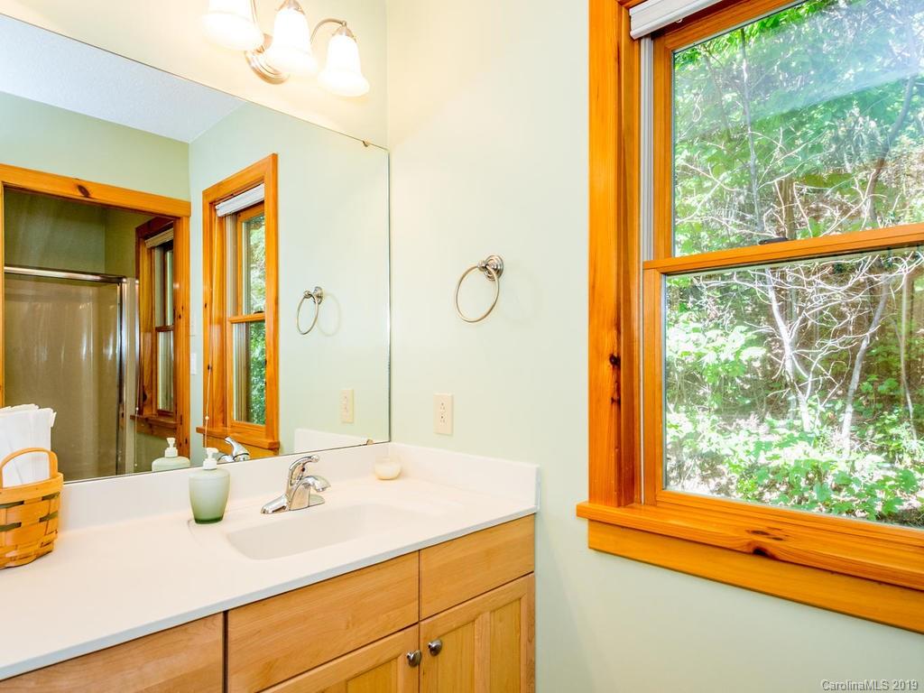 1299 Pine Ridge Road Burnsville, NC 28714 - Photo 28 of 41 a bathroom with a granite countertop sink and a mirror