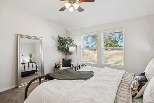a bedroom with a bed lamp and a large window