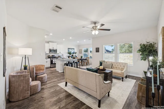 a living room with furniture kitchen view and a potted plant