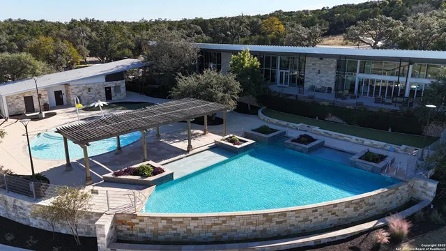 a view of a house with pool and chairs