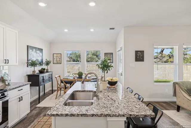 a kitchen with granite countertop a sink stove and cabinets