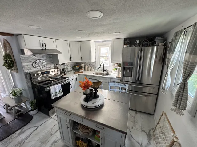 a kitchen with a refrigerator and a stove top oven