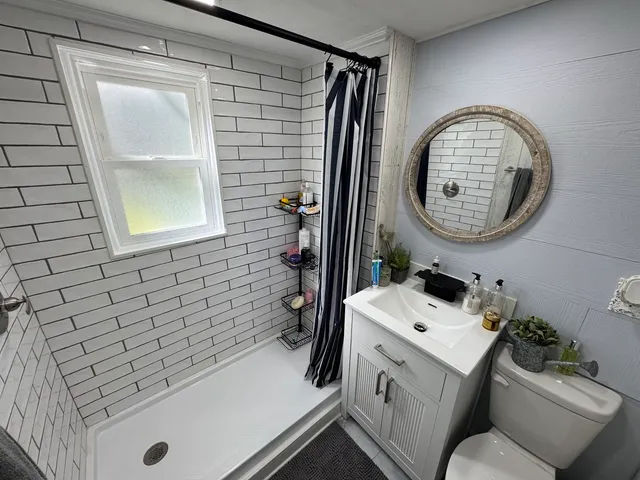 a bathroom with a sink toilet and mirror