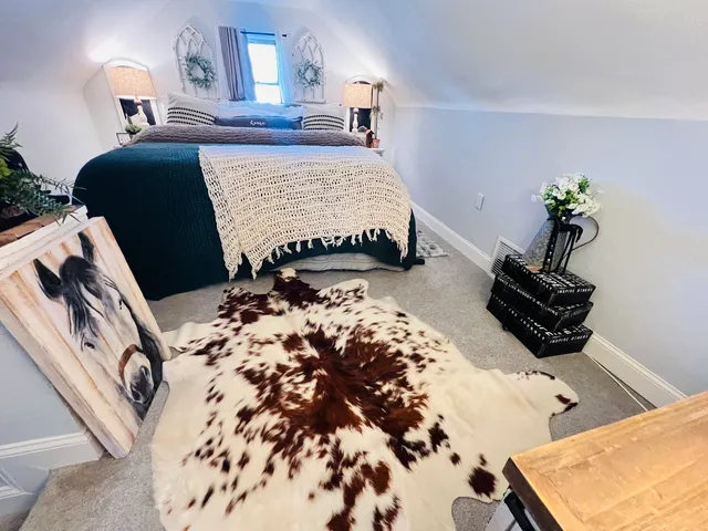 a bed sitting in a bedroom next to a window with dresser