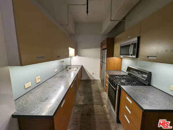 a kitchen with stainless steel appliances granite countertop a stove a sink and a refrigerator