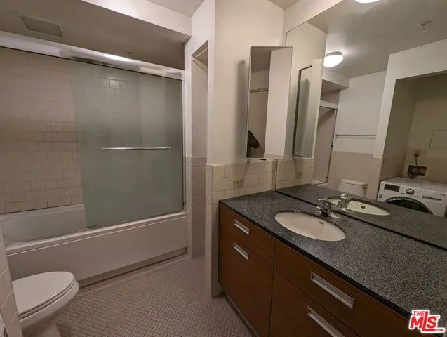 a bathroom with a sink a toilet a mirror and shower