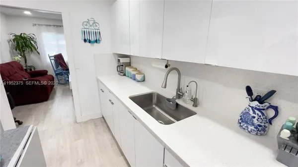 a kitchen with a sink a stove and white cabinets