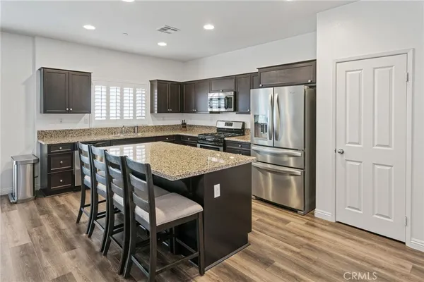 a kitchen with kitchen island a refrigerator stove and microwave