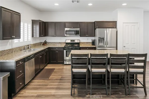 a kitchen with stainless steel appliances granite countertop a stove top oven a sink and dishwasher