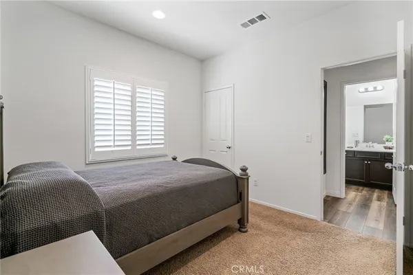 a bedroom with a bed and a view of kitchen
