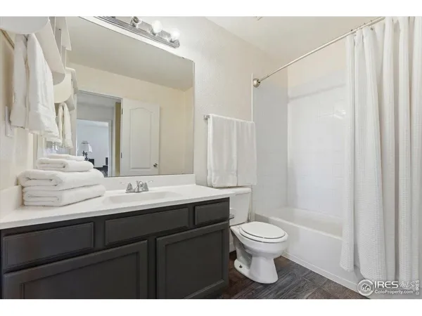 a spacious bedroom with a bed and a ceiling fan