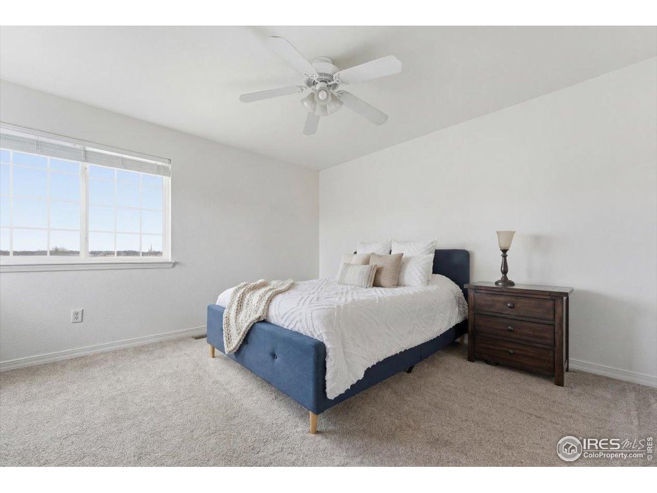 930 Button Rock Drive, Unit 64 Longmont, CO 80504 - Photo 19 of 23 a spacious bedroom with a bed and a ceiling fan