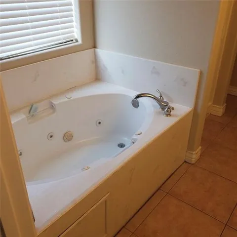 a bathroom with a tub and a window