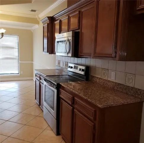 a kitchen with stainless steel appliances granite countertop a sink stove and cabinets