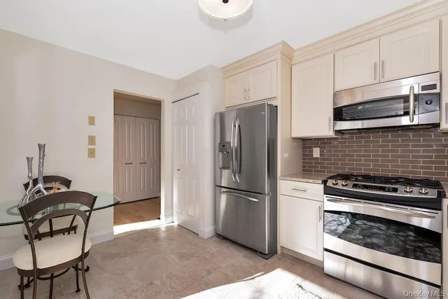 a kitchen with granite countertop white cabinets sink and stainless steel appliances