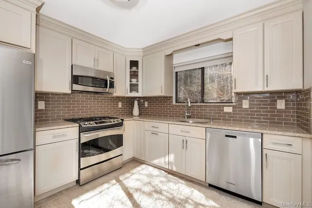 a kitchen with granite countertop a stove a sink and a microwave
