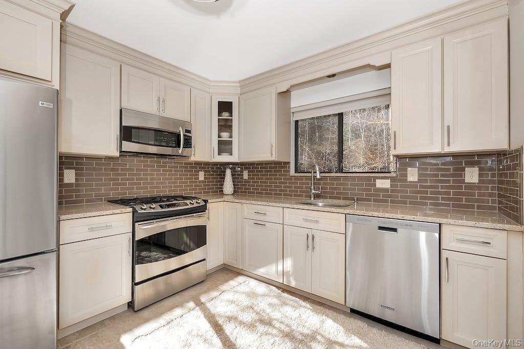 103 Rambling Brook Road Chappaqua, NY 10514 - Photo 8 of 33 a kitchen with granite countertop white cabinets sink and stainless steel appliances