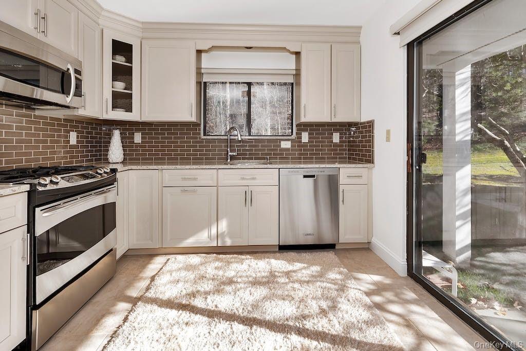 103 Rambling Brook Road Chappaqua, NY 10514 - Photo 9 of 33 a kitchen with granite countertop a stove a sink and a microwave