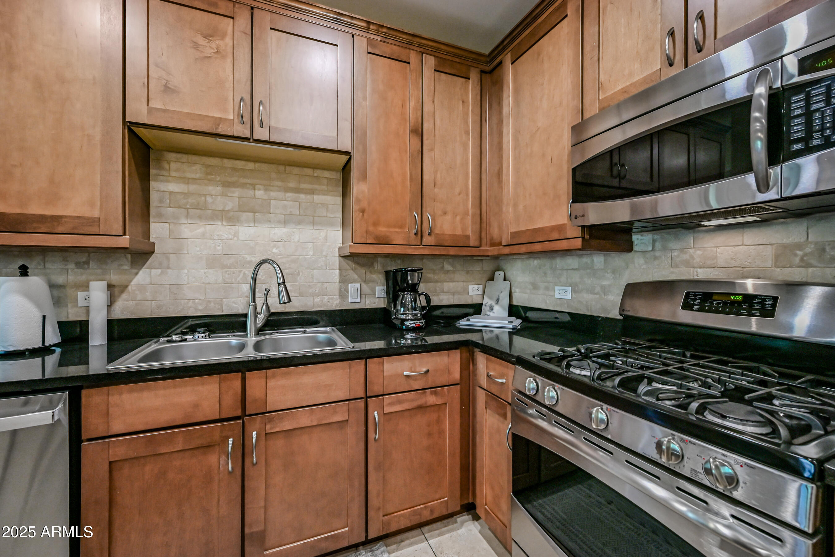 7291 North Scottsdale Road, Unit 2008 Paradise Valley, AZ 85253 - Photo 11 of 28 a kitchen with granite countertop stainless steel appliances a sink stove and microwave