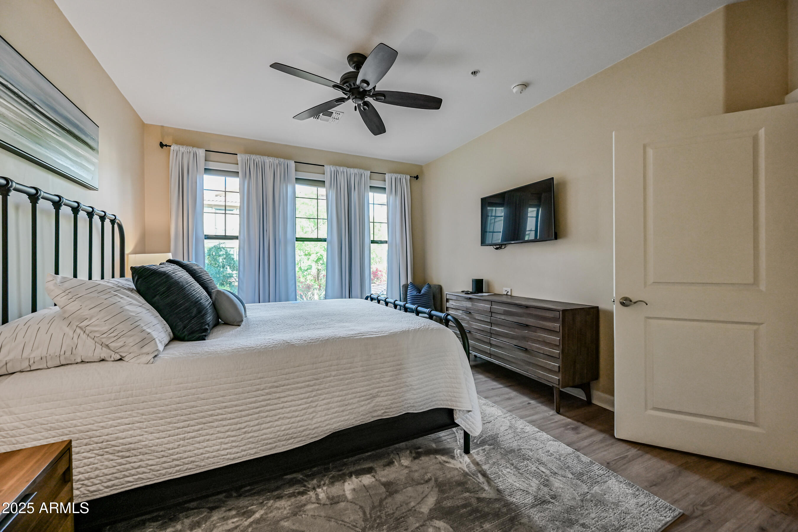7291 North Scottsdale Road, Unit 2008 Paradise Valley, AZ 85253 - Photo 21 of 28 a bedroom with a large bed a flat tv screen and a dresser