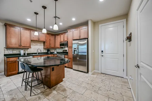 a kitchen with kitchen island a stove a sink a oven a dining table and chairs