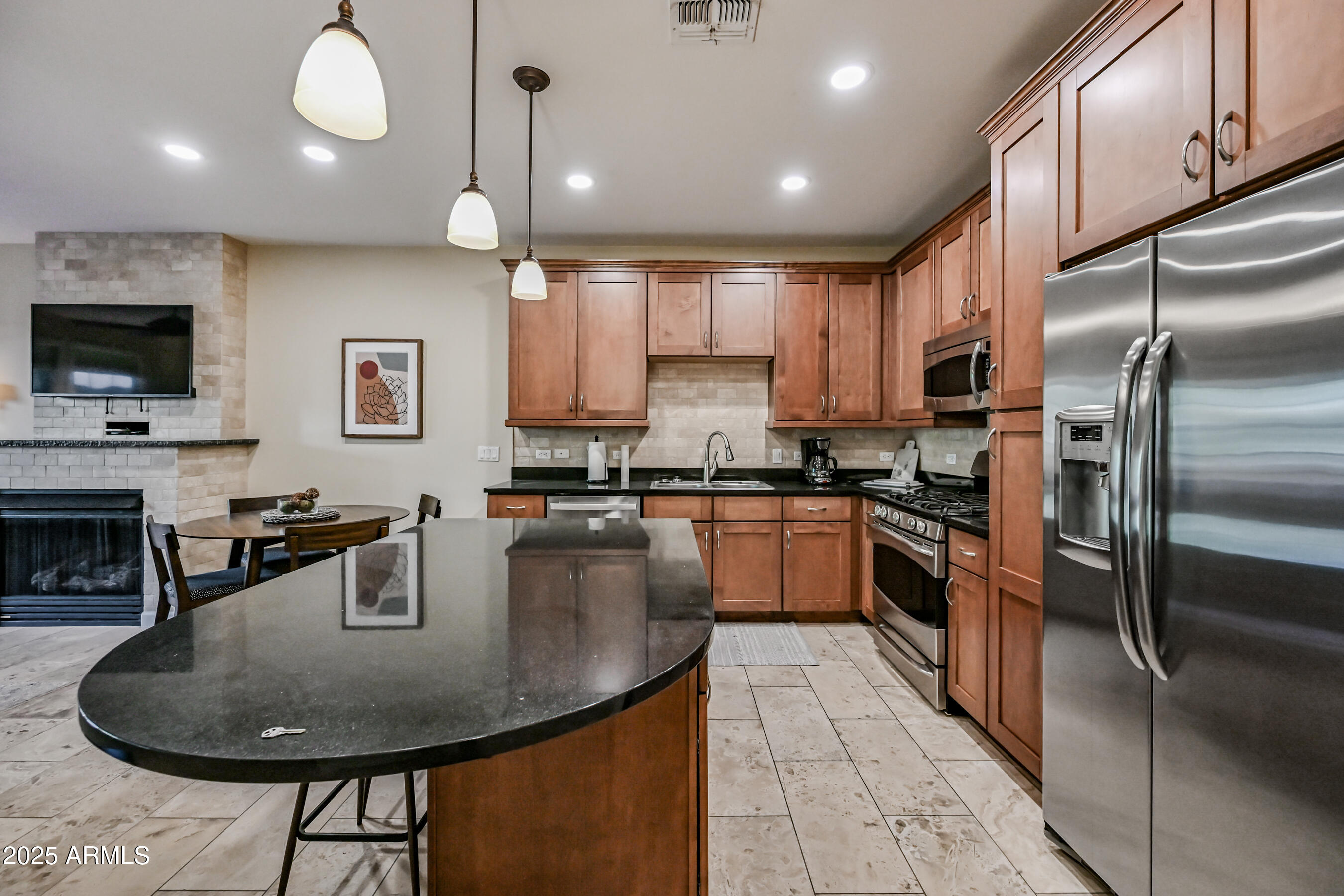 7291 North Scottsdale Road, Unit 2008 Paradise Valley, AZ 85253 - Photo 10 of 28 a kitchen with kitchen island a stove a sink a oven a dining table and chairs