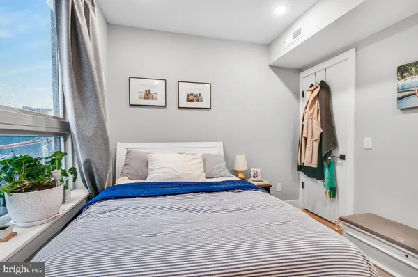 a bedroom with a bed and a potted plant
