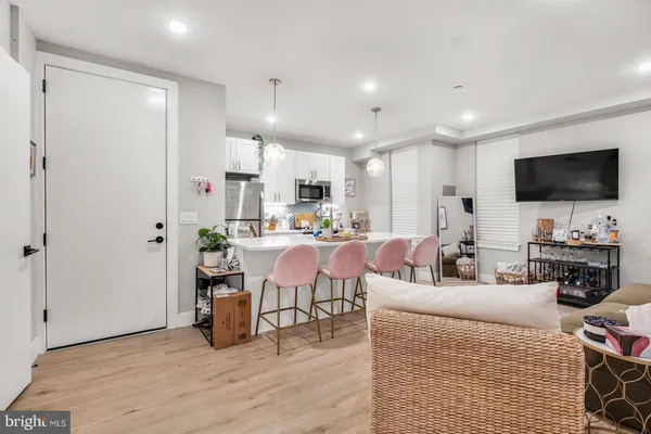a living room with stainless steel appliances furniture a fireplace and a flat screen tv