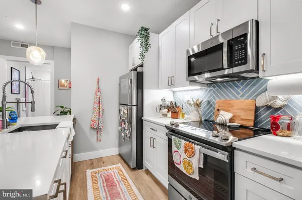 a kitchen with stainless steel appliances a microwave a stove and a sink