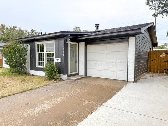 a view of a house with a wooden fence