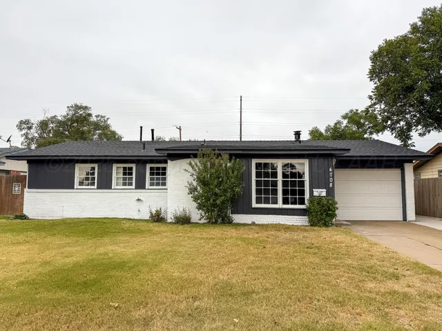 a front view of house with yard and trees in the background