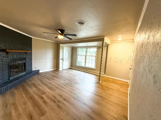 a view of an empty room with a fireplace and a window
