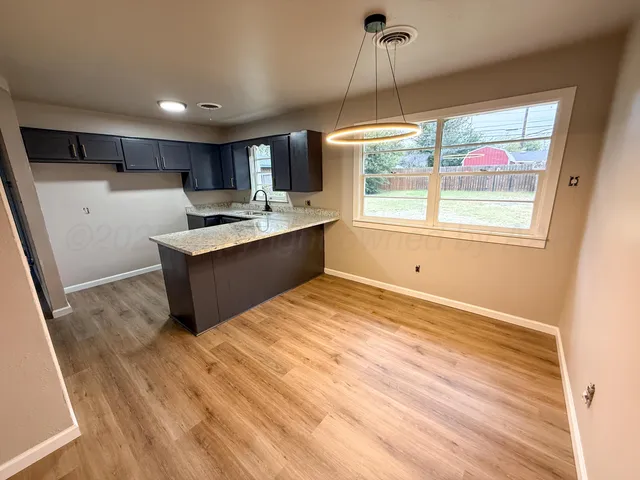a view of a kitchen with a sink and wooden floor