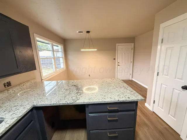 a view of kitchen island granite countertop wooden cabinets
