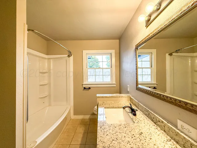 a bathroom with a tub a sink and a large mirror