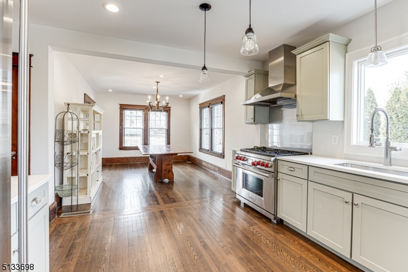11 Village Road New Vernon, NJ 07976 - Photo 11 of 26 a kitchen with stainless steel appliances a stove a sink dishwasher a refrigerator white cabinets and wooden floor next to a window