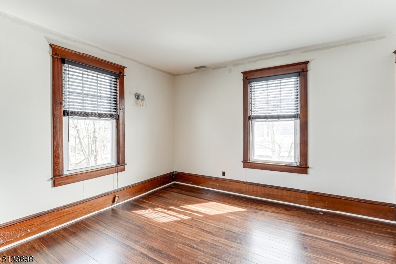 11 Village Road New Vernon, NJ 07976 - Photo 14 of 26 an empty room with wooden floor and windows