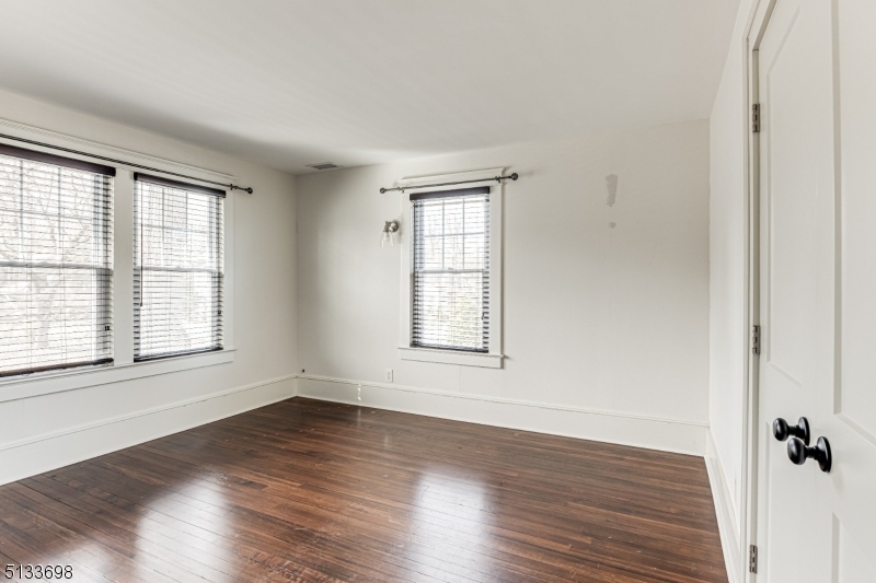 11 Village Road New Vernon, NJ 07976 - Photo 19 of 26 an empty room with wooden floor and windows