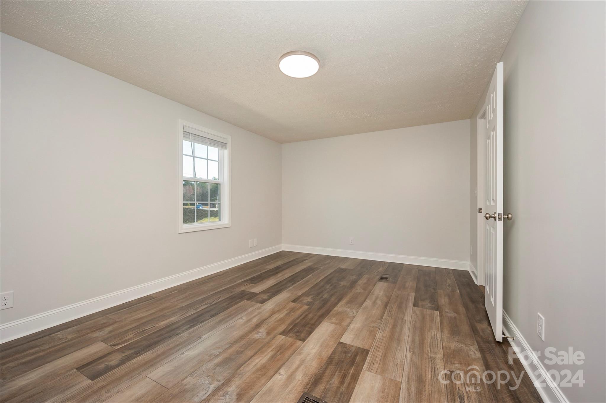 163 Mountain Creek Road Rutherfordton, NC 28139 - Photo 17 of 35 an empty room with wooden floor and windows